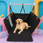 A yellow Labrador retriever lies on a black padded pet crate bed with fold-up sides and a pink support frame, photographed in a colorful studio set with blue, pink, and yellow arches and paw-print props.